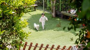 a little girl walking a white dog in a yard at Geoje Erion Pet-Friendly Pension in Geoje