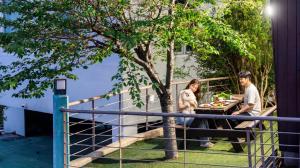 a man and a woman sitting at a table with food at Geoje Erion Pet-Friendly Pension in Geoje