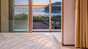 a bedroom with a large window with a view of the ocean at Geoje Erion Pet-Friendly Pension in Geoje