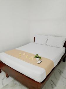 a bed with white sheets and flowers on it at DA GREA NATURAL BEACH HOTEL in Trincomalee