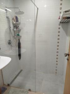 a shower with a glass door in a bathroom at mona in Sidi Rahal