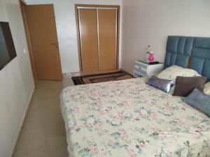 a bedroom with a bed with a floral bedspread at mona in Sidi Rahal