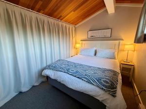 a bedroom with a bed with a white comforter at Oceanfront Studio with Loft - amazing views! in Qualicum Beach