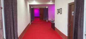 a corridor with a red carpet and a hallway with purple at Hotel Sunrise inn in Nārdiganj