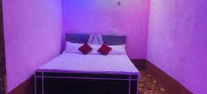 a pink room with a bed in it at Hotel Sunrise inn in Nārdiganj