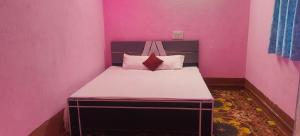 a small pink room with a bed in it at Hotel Sunrise inn in Nārdiganj