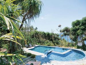 a swimming pool in a resort with palm trees at Park Paradise in Galle