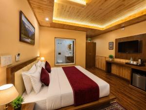 a bedroom with a large bed and a television at Mist Valley By Zenia in Fagu