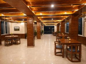 a dining room with wooden tables and chairs at Mist Valley By Zenia in Fagu