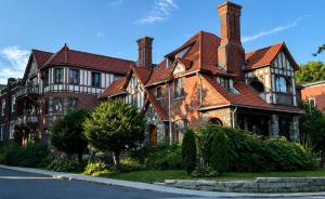 a large brick house with a red roof at Winston Churchill - le charme Tudor au cœur de Sherbrooke in Sherbrooke +7 photos