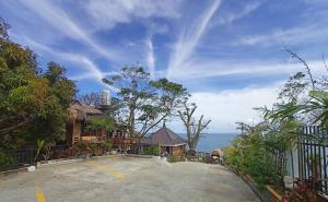 an empty parking lot next to a house and the ocean at Cliff Cabanas by Hiverooms in Catmon