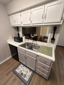 a kitchen with white cabinets and a sink at 2 King Suites w/ Private Baths + Workspaces | LSU in Baton Rouge