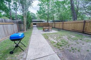 a barbecue grill in a backyard with a fence at 2 King Suites w/ Private Baths + Workspaces | LSU in Baton Rouge