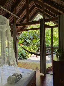 a bed in a room with a large window at Dalakit House Villa Two in Siquijor