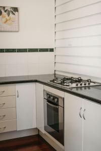 a kitchen with a stove and white cabinets at Heritage Hideaway in Bunbury