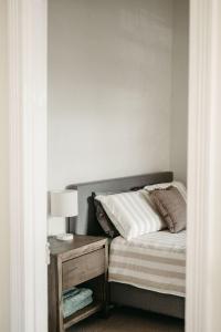 a bedroom with a bed and a table with a lamp at Heritage Hideaway in Bunbury