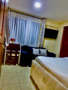 a bedroom with two beds and a table and a window at Rees haven in Nanyuki