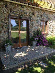 a stone house with a wooden door and flowers at Gites du Manoir in Runan