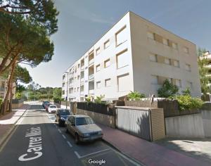 un edificio con coches aparcados al lado de una calle en Apartments Beach Club, en Lloret de Mar