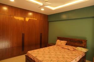 a bedroom with a bed and wooden cabinets at Sunstar in Coimbatore