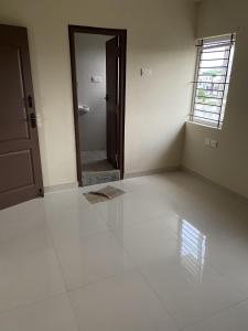 an empty room with a door and a window at Sunstar in Coimbatore +2 photos