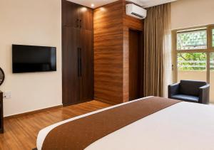 a hotel room with a bed and a television at Chelsea Hotel Abuja in Abuja