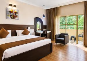 a hotel room with a bed and a chair at Chelsea Hotel Abuja in Abuja