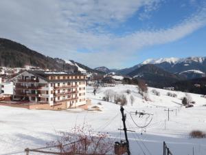 un edificio en la nieve con montañas en el fondo en Donovaly Panorama 31C, en Donovaly