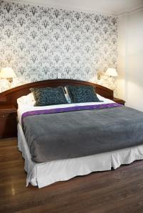 a bedroom with a large bed with blue pillows at Hotel Castilla Real in Pereira