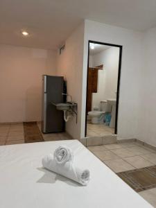 a towel sitting on a bed in a bathroom at Casa Dixam Luum in Puerto Morelos