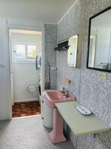 a bathroom with a pink sink and a mirror at Bonnydoon at Hat Head - 5 Oak Street in Hat Head +15 photos