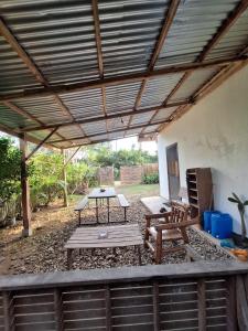 a patio with a picnic table and chairs under a roof at Lio House 2 bedroom in El Nido Airport