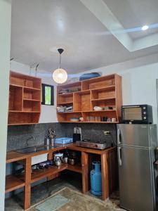 a kitchen with wooden cabinets and a stainless steel refrigerator at Lio House 2 bedroom in El Nido Airport