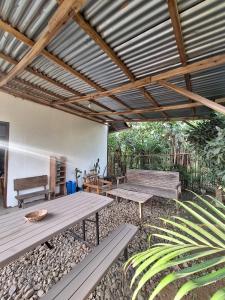 a patio with picnic tables and benches under a roof at Lio House 2 bedroom in El Nido Airport +25 photos