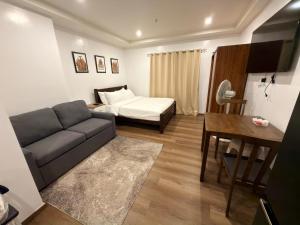 a living room with a couch and a bed at Raya's Staycation Megatower 7 Baguio City in Baguio
