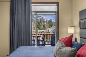 a bedroom with a bed and a view of a mountain at The Eagle Suite at Stoneridge Mountain Resort in Canmore
