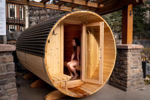 a woman sitting in a wooden hobbit house at The Eagle Suite at Stoneridge Mountain Resort in Canmore