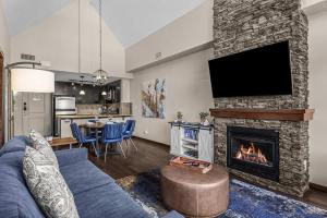 a living room with a blue couch and a fireplace at The Eagle Suite at Stoneridge Mountain Resort in Canmore +12 photos