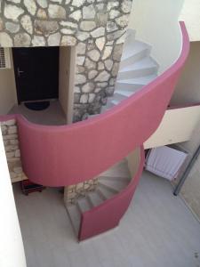 una escalera de caracol en una casa con una pared de piedra en Apartment Iva, en Fažana