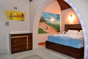 a bedroom with a bed and a painting on the wall at Tuya Abu Simbel Hotel in Abu Simbel
