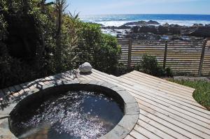 a pool of water on a wooden deck next to the ocean at Hotel 8 al Mar in Pichilemu