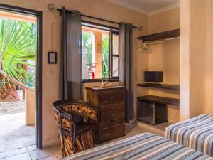 a bedroom with a bed and a desk and a window at Barrio Latino Hotel Riviera Maya in Playa del Carmen