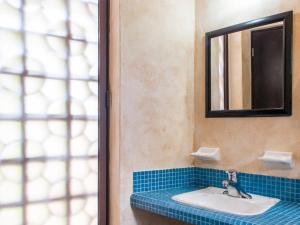 a bathroom with a sink and a mirror at Barrio Latino Hotel Riviera Maya in Playa del Carmen