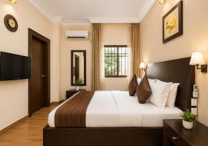 a hotel room with a bed and a television at Chelsea Hotel Abuja in Abuja +11 photos