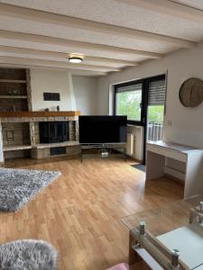 a living room with wooden floors and a large flat screen tv at Ferienhaus Seilerbahn 17 in Vallendar