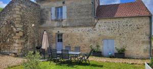 a table and chairs in front of a building at Le clos Champlieu in Orrouy