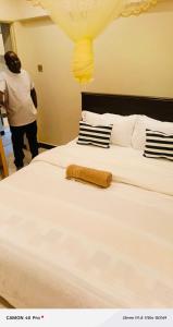 a large white bed with a towel on it at Cozy homes kisii in Kisii