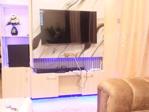 a living room with a television on a wall at Cozy homes kisii in Kisii