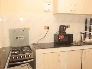 a kitchen with a stove and a microwave at Cozy homes kisii in Kisii +5 photos