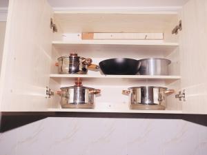 a kitchen with two pots and pans on shelves at Cozy homes kisii in Kisii